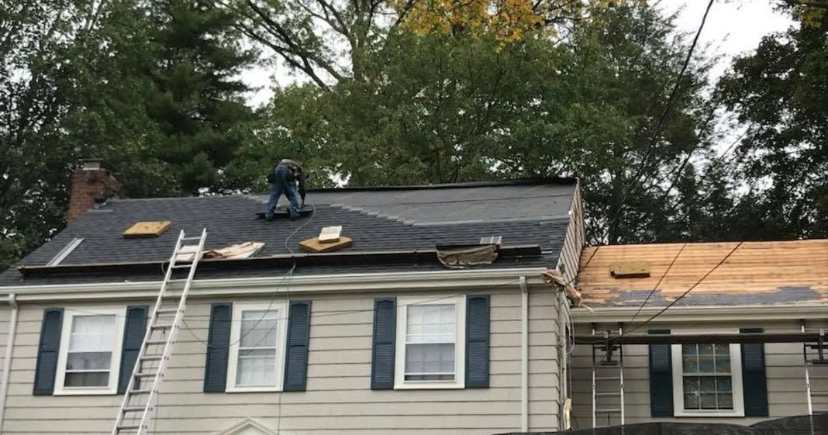 Protective roof underlayment being installed beneath asphalt shingles on a Massachusetts home.
