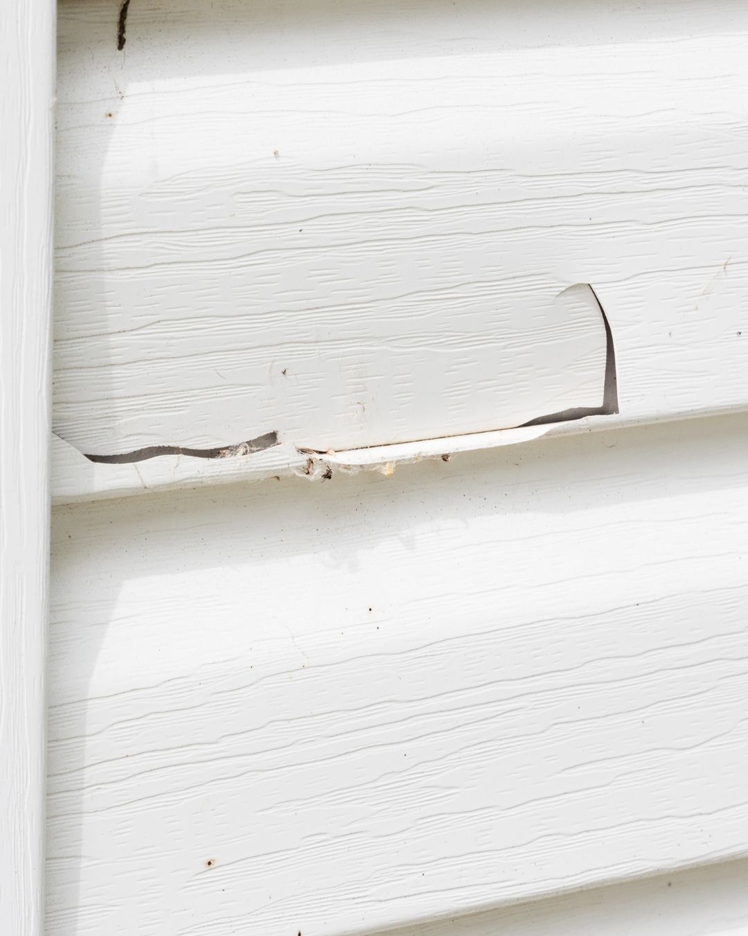 Professional inspection of damaged residential siding on a Massachusetts home.