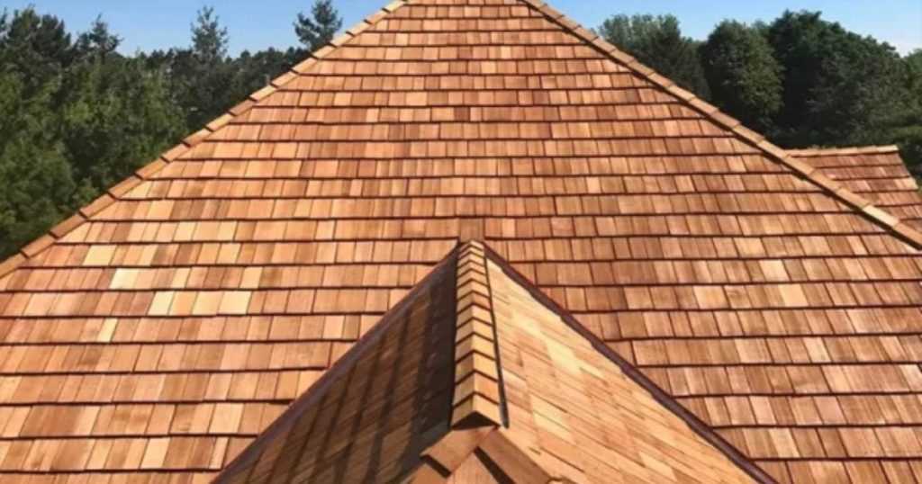 Completed natural cedar shingle roof with detailed hips and rooflines.