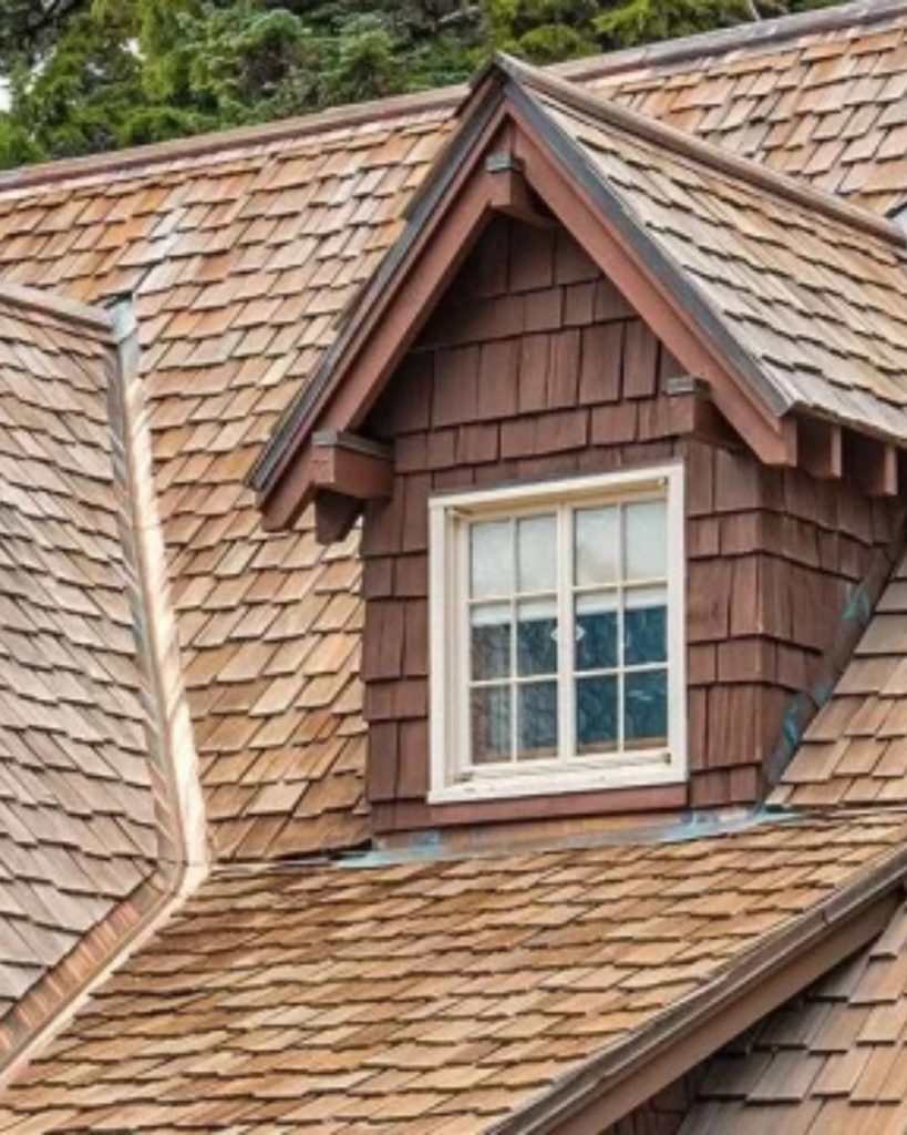 Natural cedar shingle roofing installed across a detailed residential roof with dormers.