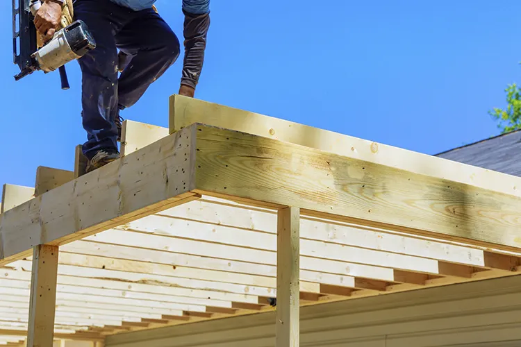 Carpenter building a wooden structural frame for a home exterior in Massachusetts