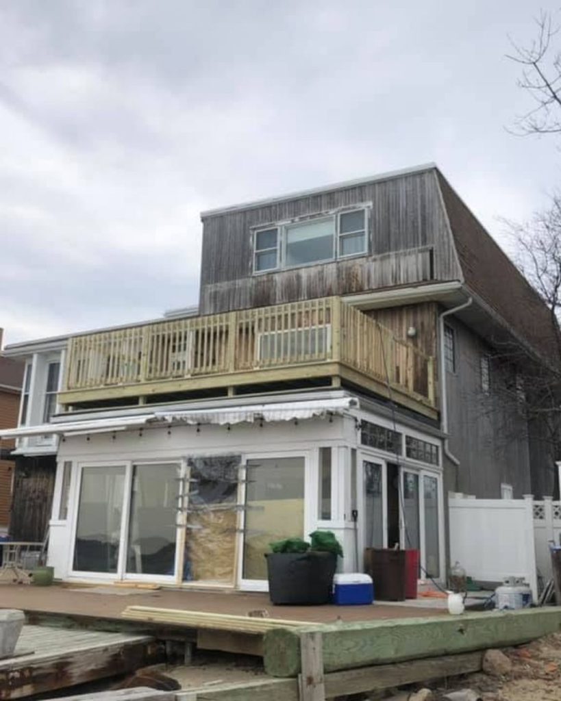 Elevated wood deck construction with new decking and railings