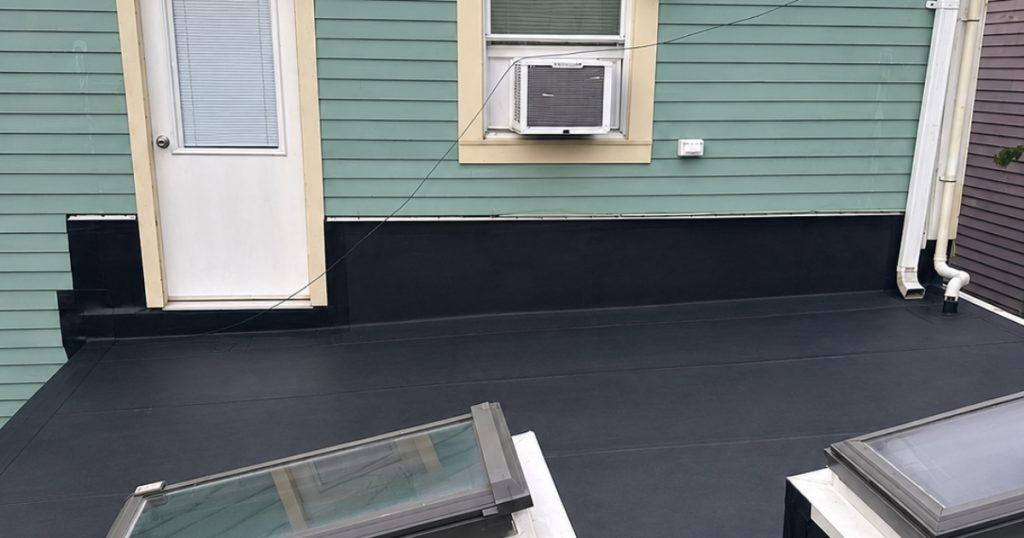 EPDM rubber roofing installed on a low-slope residential porch roof in Massachusetts.