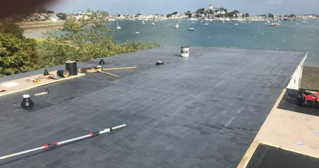 Cleanup after completing an EPDM rubber roofing project in Massachusetts.
