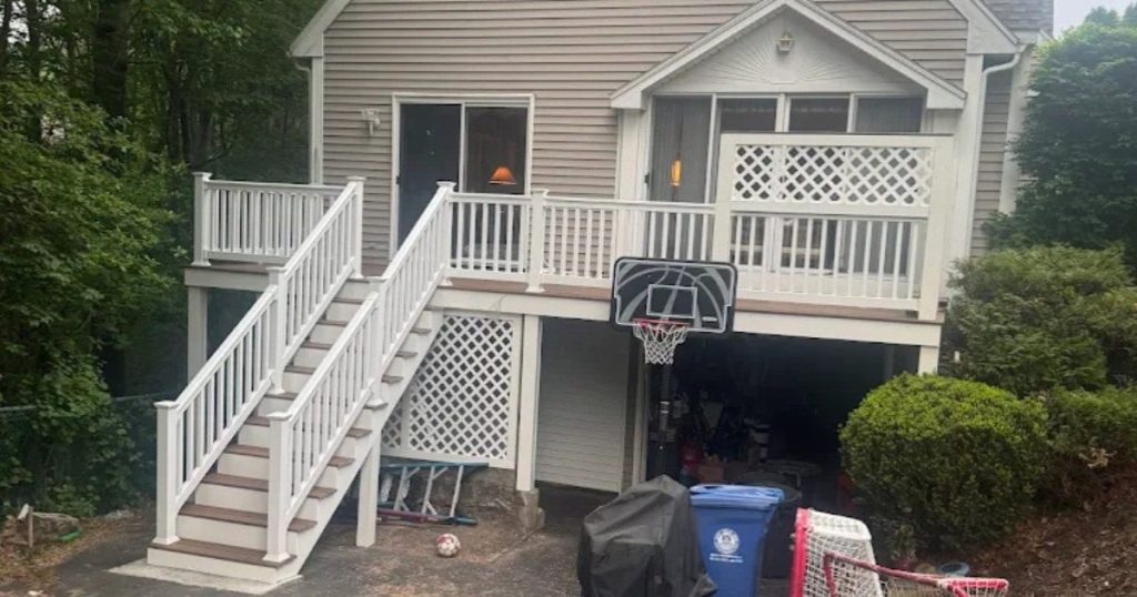 Completed residential porch with exterior stairs and white railings.