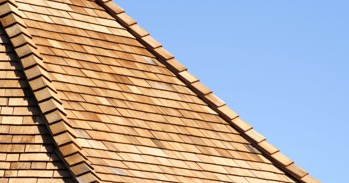 Close view of natural cedar shingles installed on a residential roof.