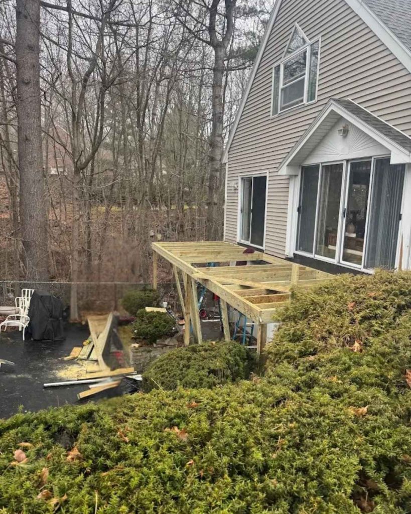 New porch framing under construction beside residential home