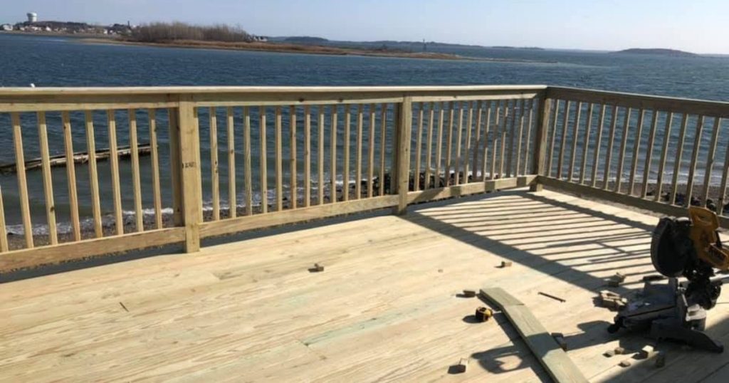Completed residential wood deck with railings built by Clough Construction.