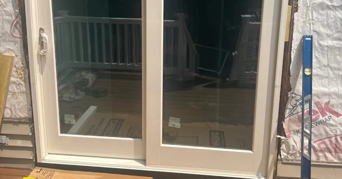 Residential replacement window being sealed and insulated during installation in Massachusetts.