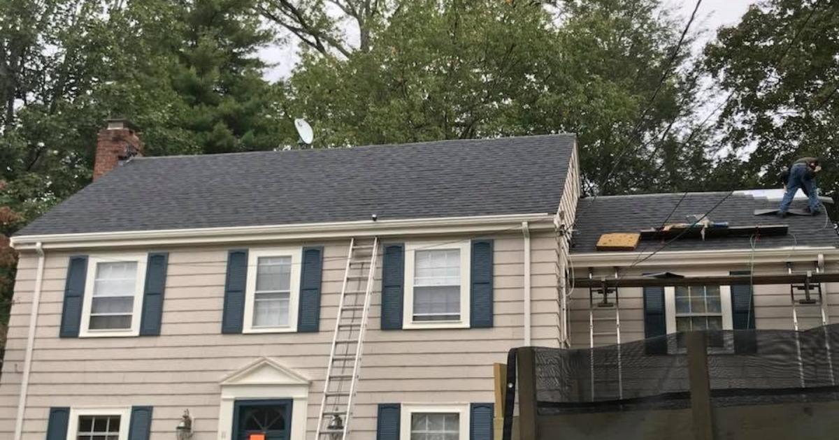 Residential asphalt roof replacement with new shingles being installed.