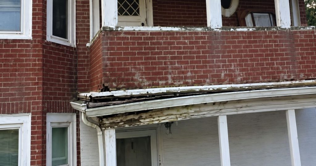 Professional inspection of residential gutters and roofline drainage on a Massachusetts home.