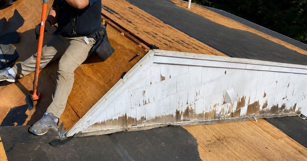 Existing asphalt roofing being removed during residential roof replacement