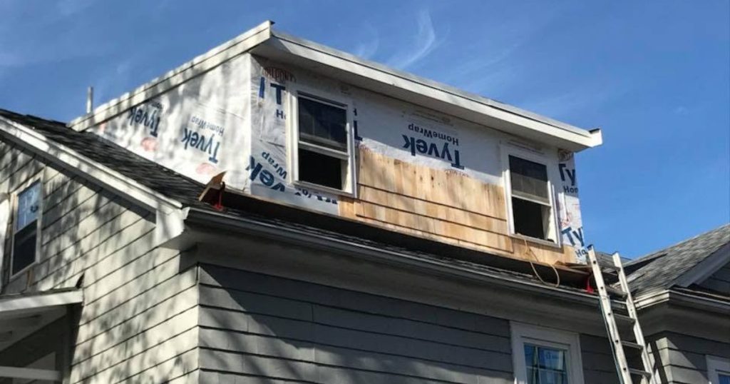 Professional inspection of existing siding and exterior trim on a Massachusetts home.