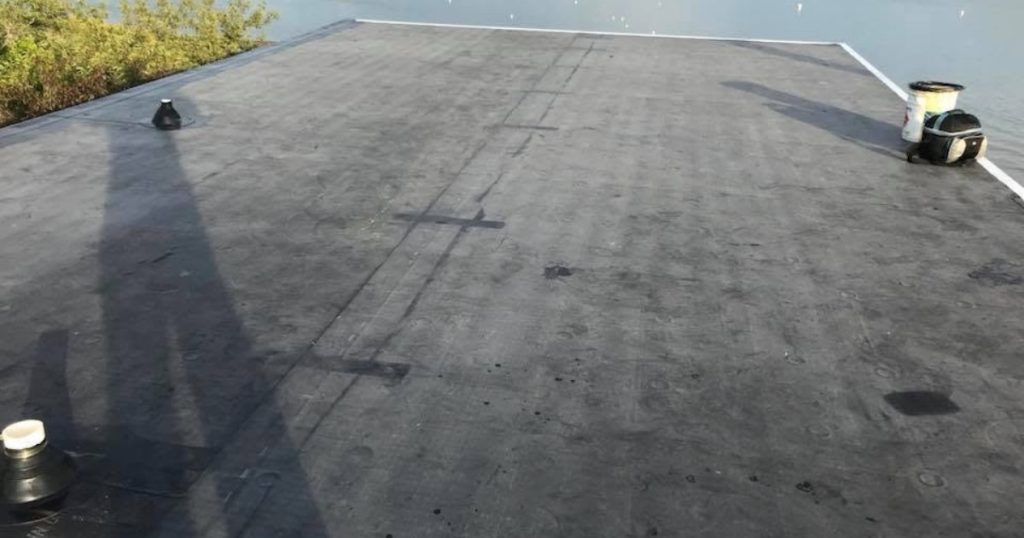 Completed EPDM rubber roofing installation on a waterfront property